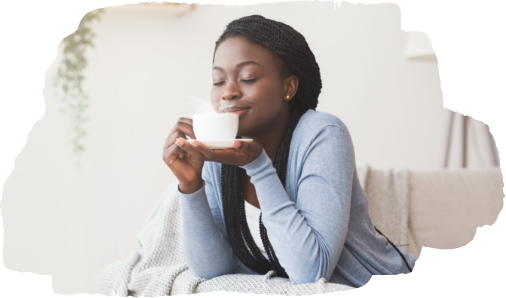 woman sitting on a couch smelling coffee